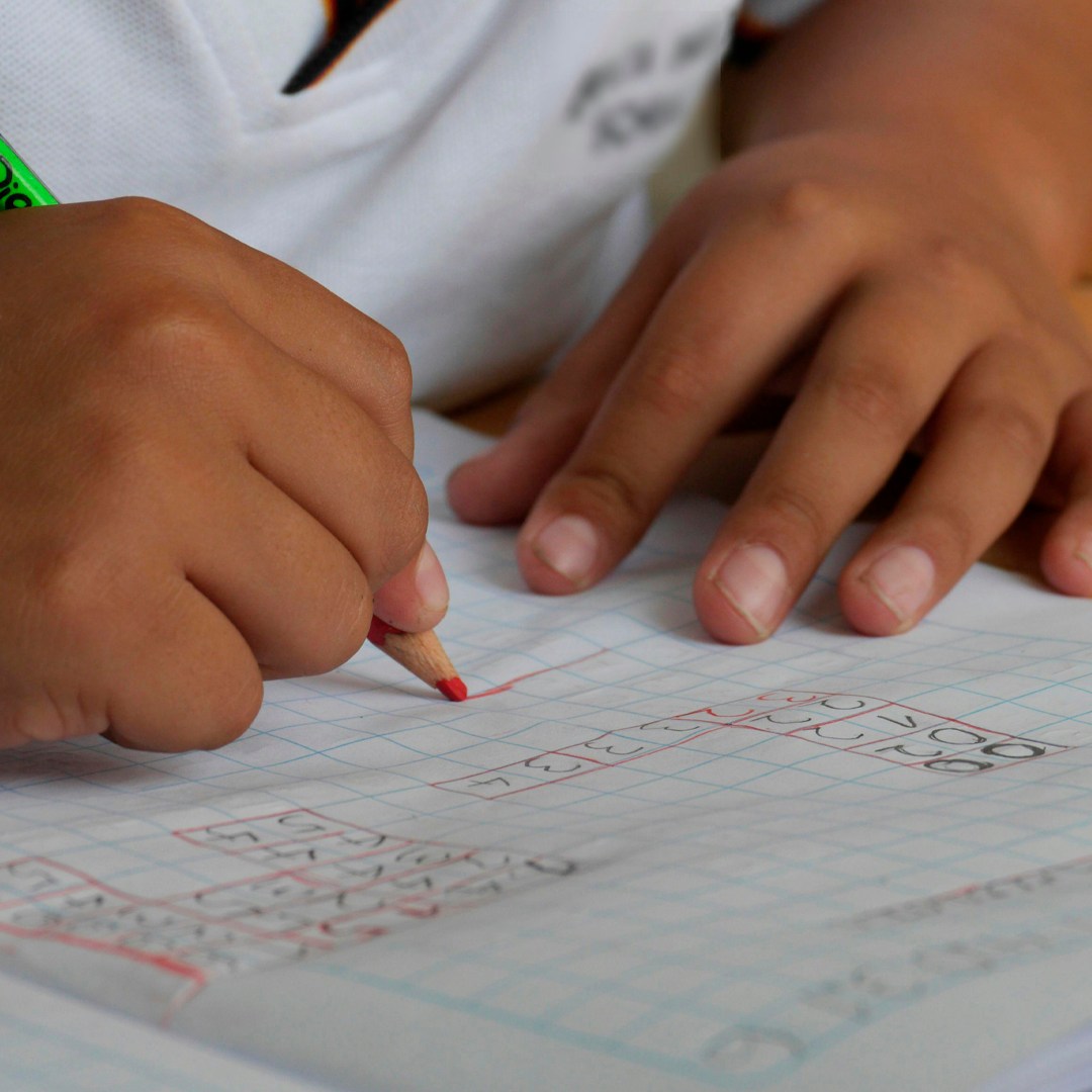 Imagem de criança escrevendo em um caderno.